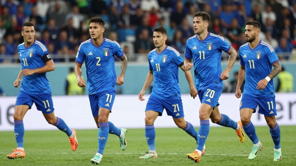 Italian national football team players in blue kits on the field.